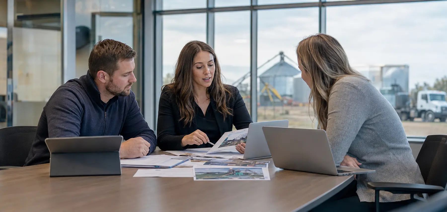 Reon coordinator reviewing project documents and site photos with clients